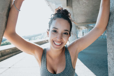 Portrait of young woman standing against wall