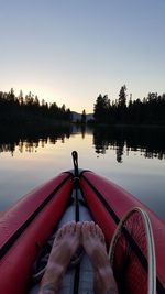 Low section of man on boat in lake against sky