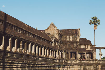 Low angle view of old ruined temple against clear blue sky during sunny day