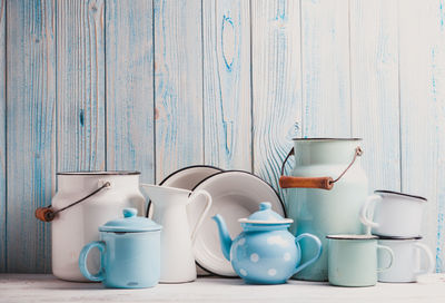 Coffee cup on table against white wall