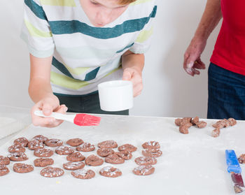 People making cookies on table at home