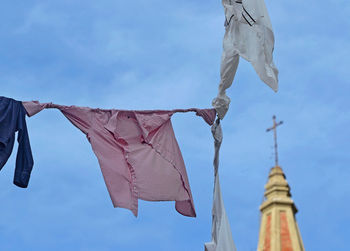 Low angle view of clothes hanging against sky