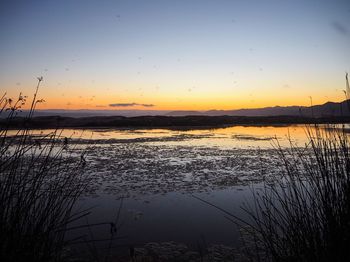 Scenic view of lake against sky during sunset