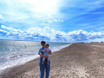 Boy on beach against sky