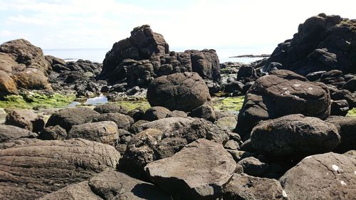 Rocks on beach against sky