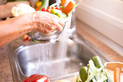 Cropped image of person preparing food in kitchen at home