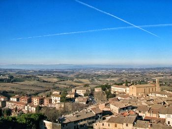 Aerial view of cityscape against blue sky