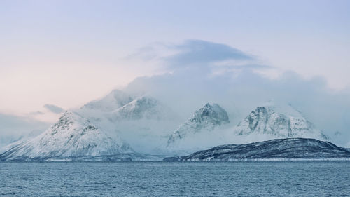 Scenic view of sea against snowcapped mountain