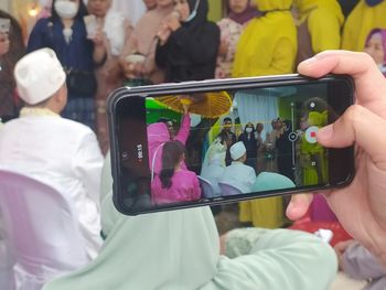 Midsection of woman photographing with mobile phone