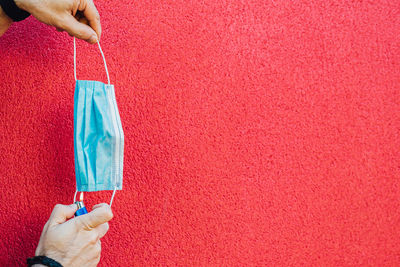 Close-up of hand holding red wall