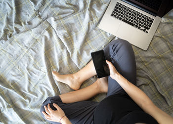 Low section of woman lying on bed