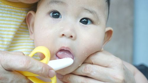 Close-up portrait of boy holding baby hand