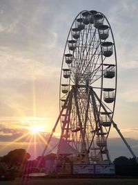 Low angle view of ferris wheel against sky during sunset