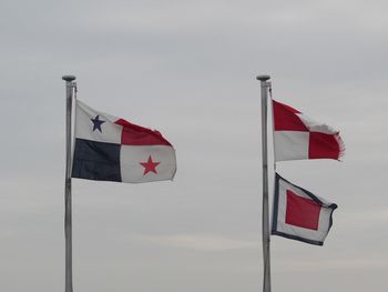Low angle view of flag flags against sky