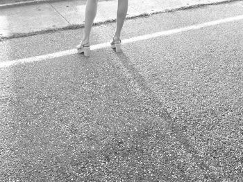 Low section of person walking on road
