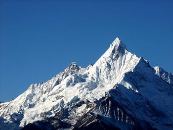 Scenic view of snowcapped mountains against clear blue sky