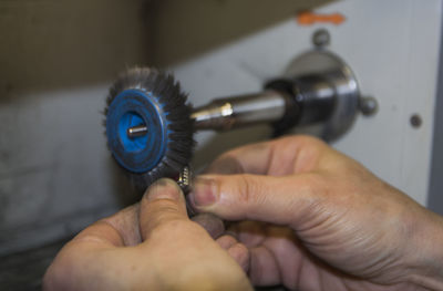 Close-up of hands polishing metal in factory