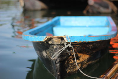 Close-up of old boat moored on lake