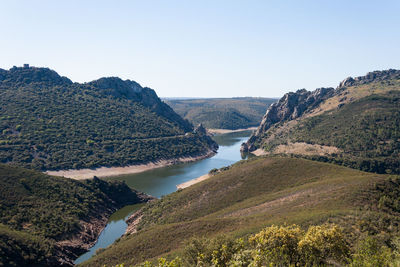 High angle view of river and mountains against clear sky