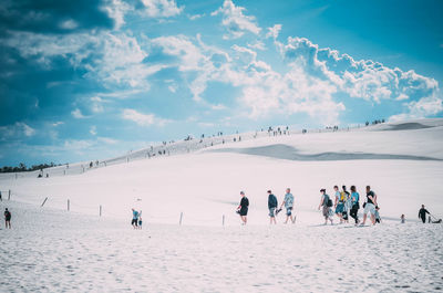 People at beach against sky