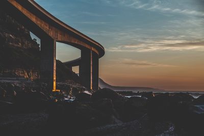 Bridge at coast against sky during sunset