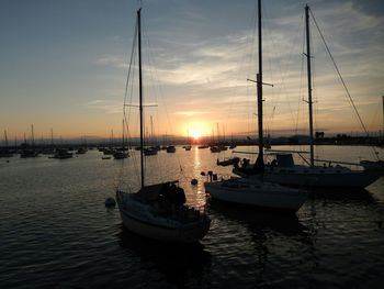 Sailboats in sea at sunset