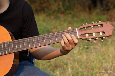 Midsection of man playing guitar