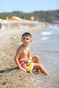 Portrait of boy sitting at beach