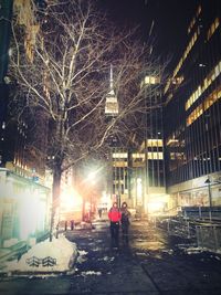 Woman standing in illuminated city at night