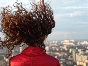 Rear view of woman with tousled hair looking at cityscape