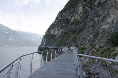 Footbridge amidst mountains against sky