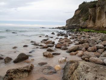 Rocks on beach against sky