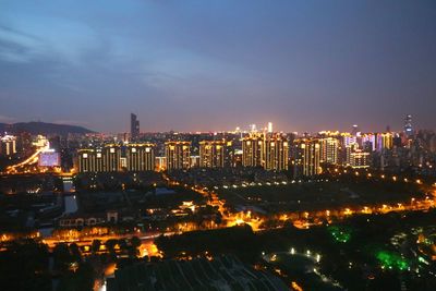 Illuminated cityscape against sky at night