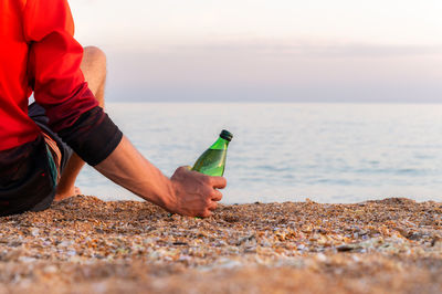 Rear view of man sitting at beach