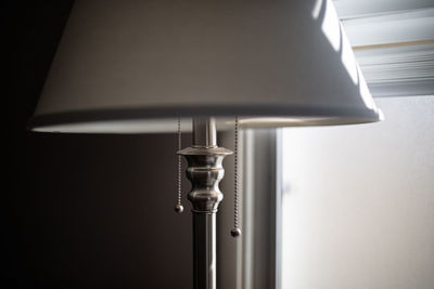 Close-up of electric lamp against wall at home