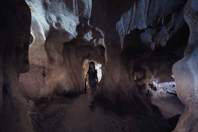 Rear view of man standing in cave