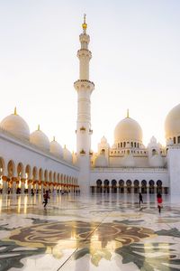 Sheikh zayed mosque in abu dhabi during sunset with playing children in the middle