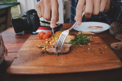Midsection of person preparing food on cutting board