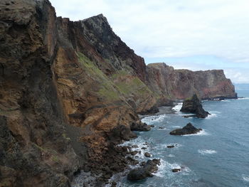 Rock formations by sea against sky