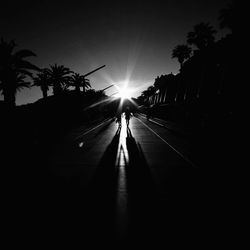 Silhouette of people walking on road