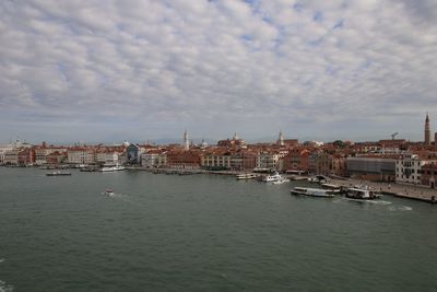 View of buildings in city against cloudy sky