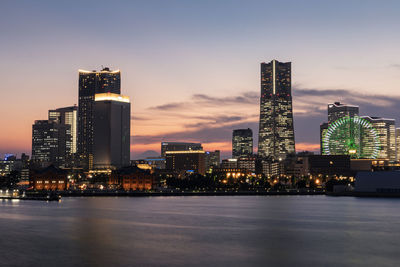 Illuminated buildings in city against sky