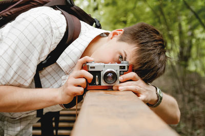 Young man takes a shoot with old fashioned film camera. photographer with retro photo camera.