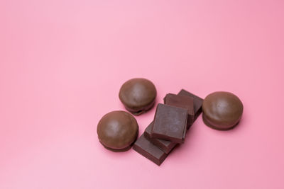 High angle view of chocolate candies against pink background