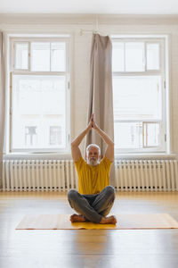 Man with gray hair meditates and does breathing exercises. sports fitness and physical exercises for