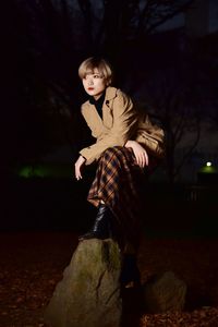 Portrait of girl standing on rock at night