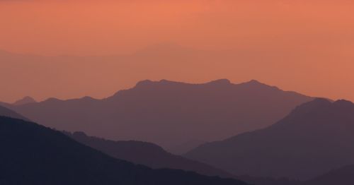 Scenic view of silhouette mountains against sky during sunset