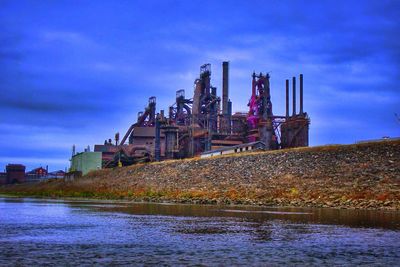 Industrial buildings against cloudy sky