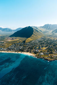 Scenic view of lake and mountains against clear blue sky