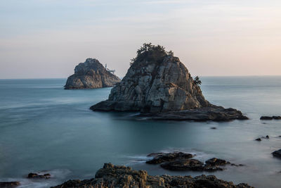 Scenic view of rocks in sea against sky